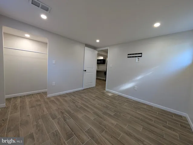 a view of empty room with window and wooden floor