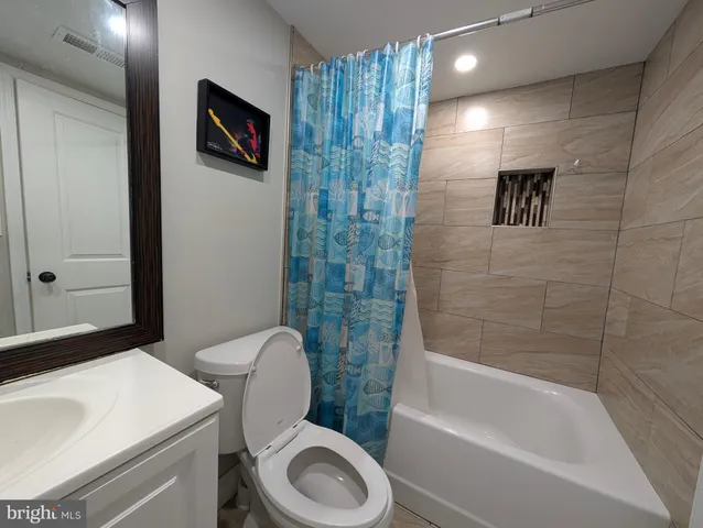 a bathroom with a toilet and a mirror