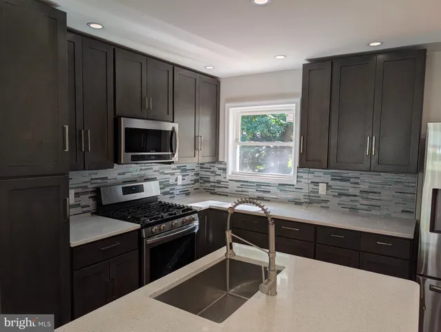 a kitchen with granite countertop wooden cabinets and a stove top oven