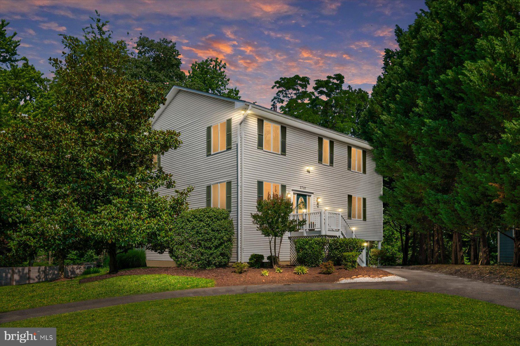 a front view of a house with a yard and green space