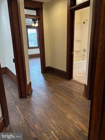 a view of a hallway with wooden floor and staircase