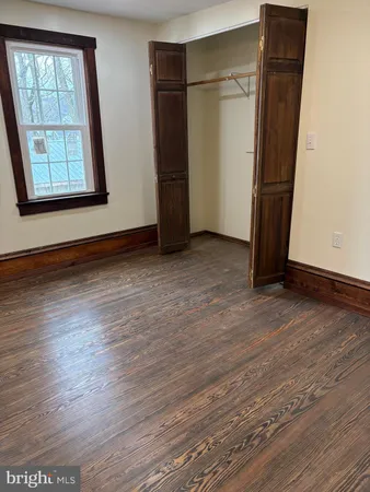 an empty room with wooden floor and a window