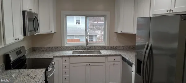 a kitchen with a sink stove and refrigerator