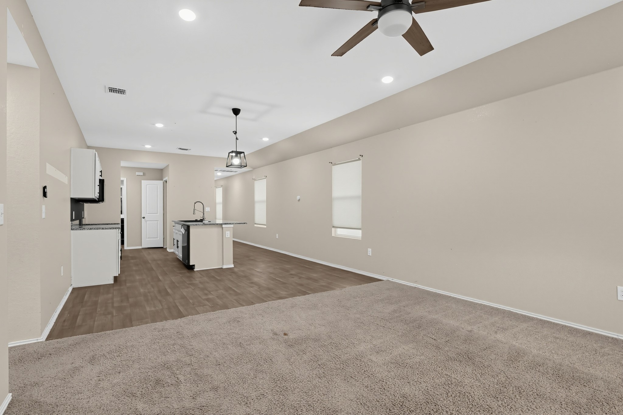 11810 Pyrite Road Manor, TX 78653 - Photo 36 of 38 An open floor plan seamlessly connects the carpeted living area to the adjacent kitchen.
