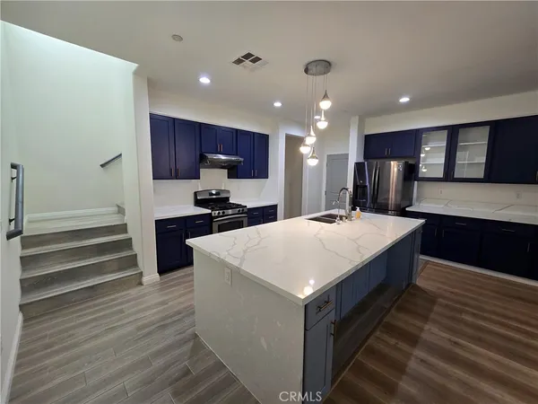 a large kitchen with kitchen island a sink stainless steel appliances and cabinets