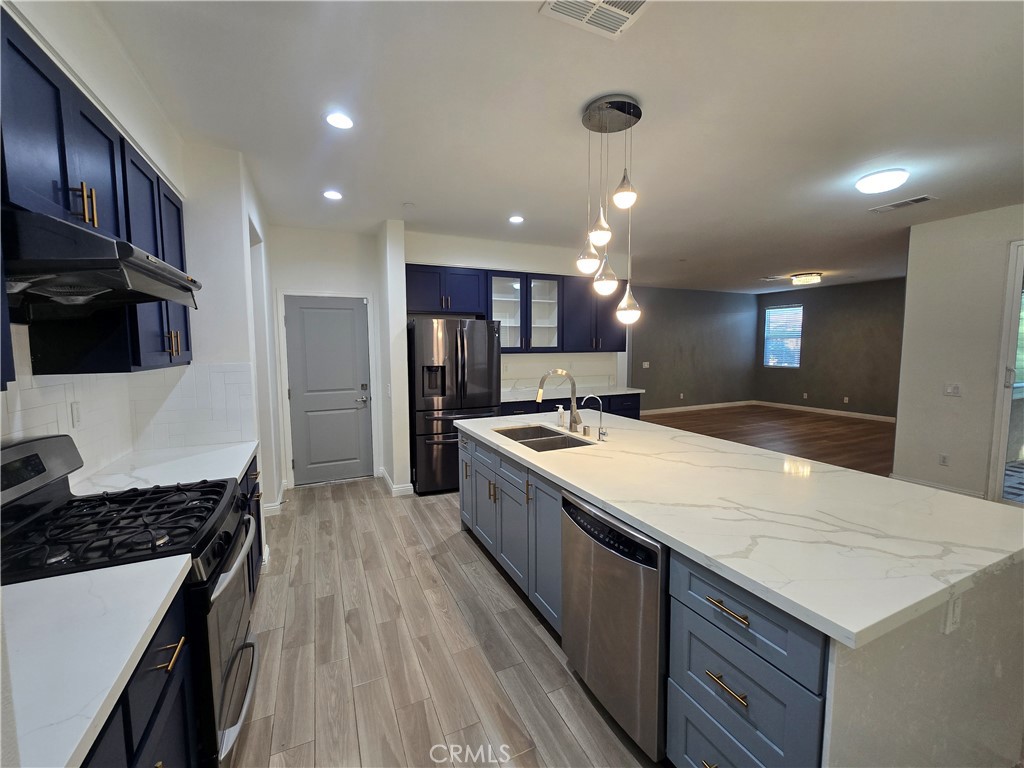 220 West Via Rua Flores Ontario, CA 91762 - Photo 18 of 51 a large kitchen with stainless steel appliances kitchen island granite countertop a large counter top a stove and a refrigerator