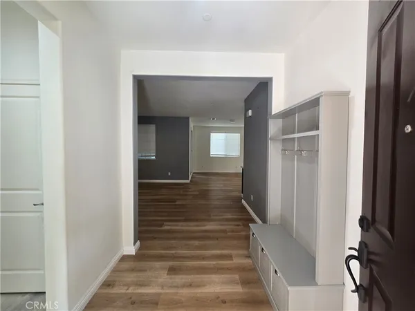 a view of a hallway with wooden floor and stairs