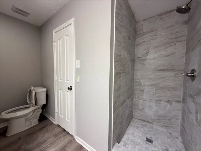 a bathroom with a toilet and a shower