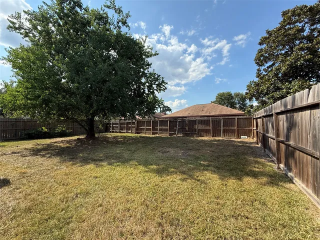 a view of a house with backyard and trees