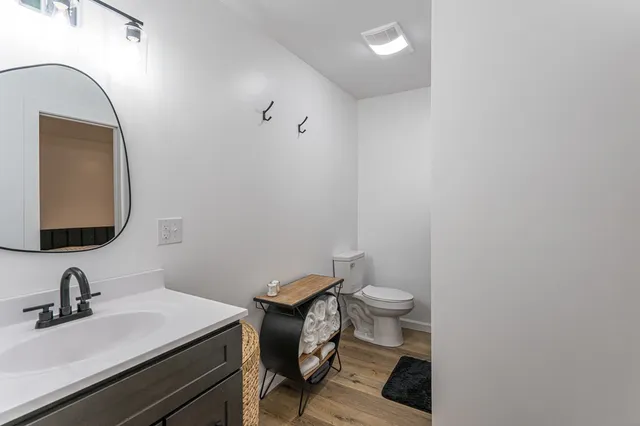 a bedroom with two beds and wooden floor