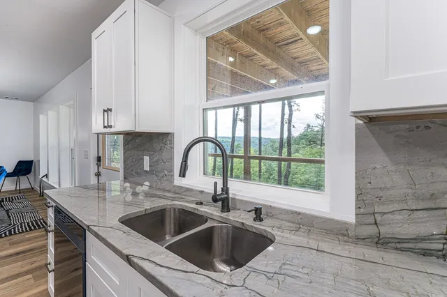 a living room with furniture a chandelier and a wooden floor