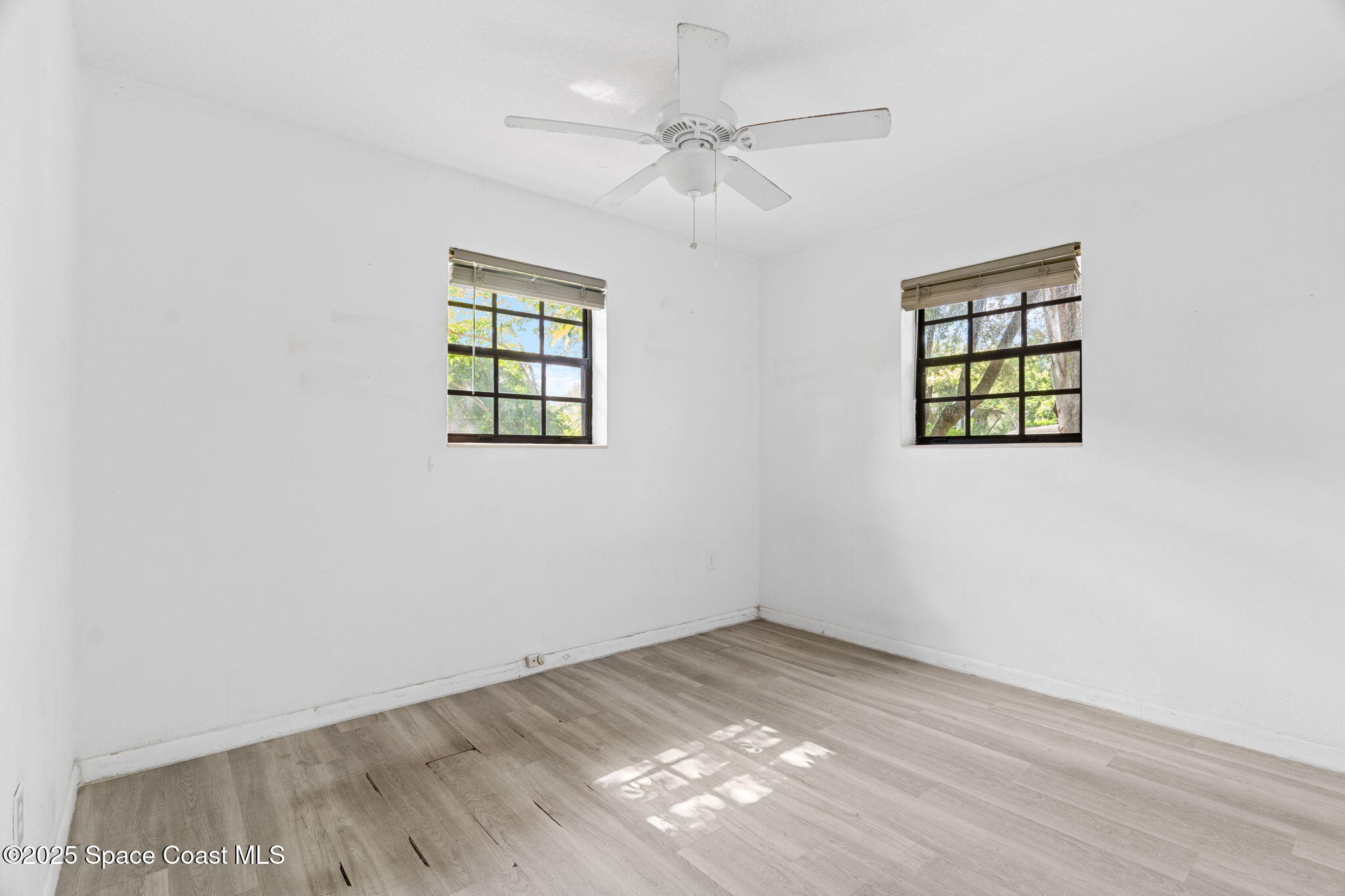 504 Cornell Avenue Melbourne, FL 32901 - Photo 8 of 24 an empty room with windows and fan