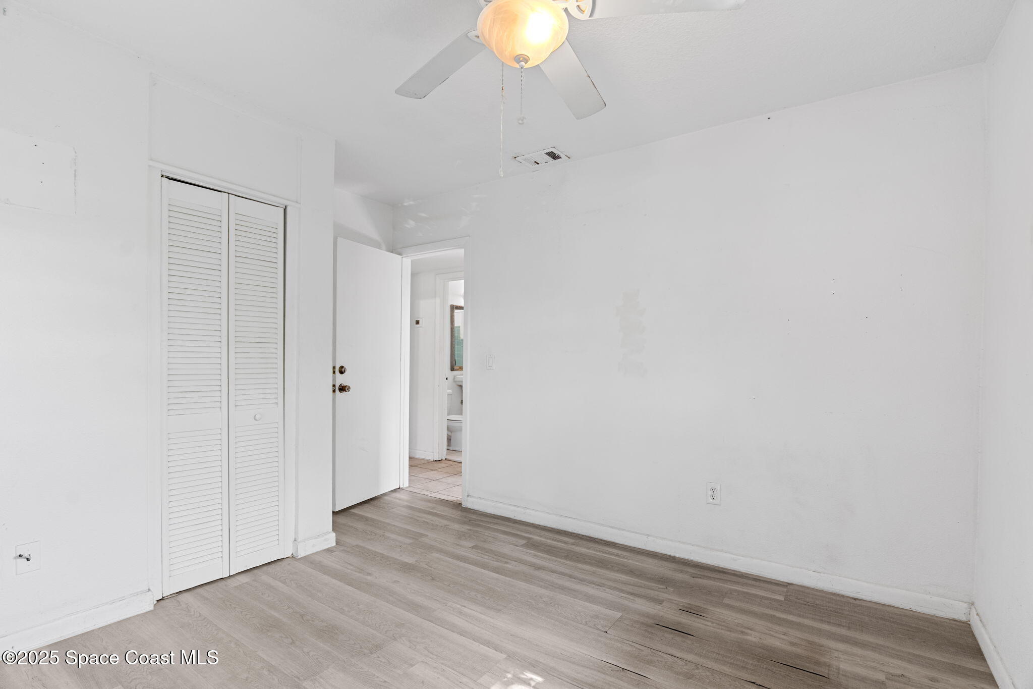 504 Cornell Avenue Melbourne, FL 32901 - Photo 9 of 24 a view of an empty room with wooden floor and a window