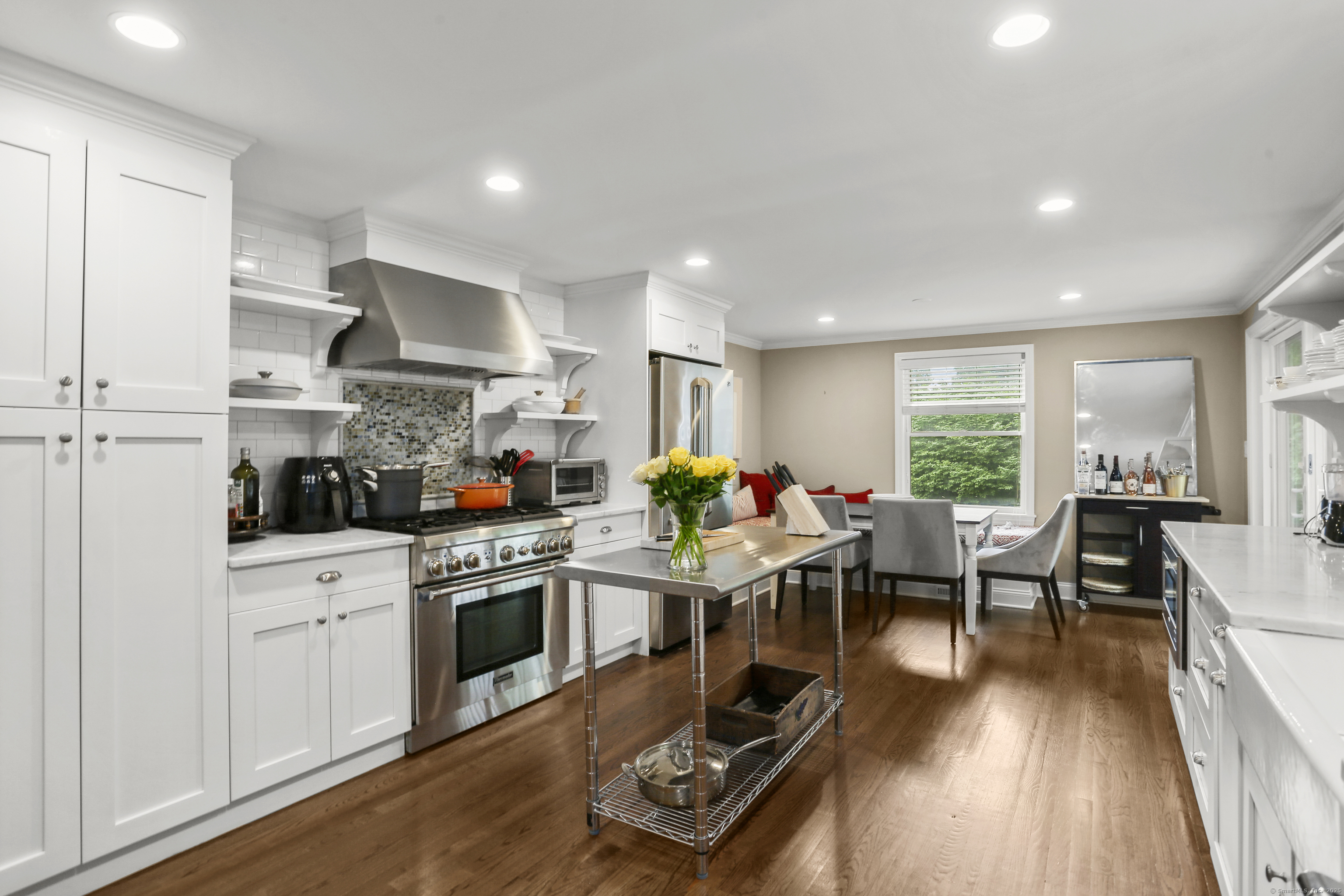 a kitchen with stainless steel appliances a stove a sink a refrigerator and wooden floor