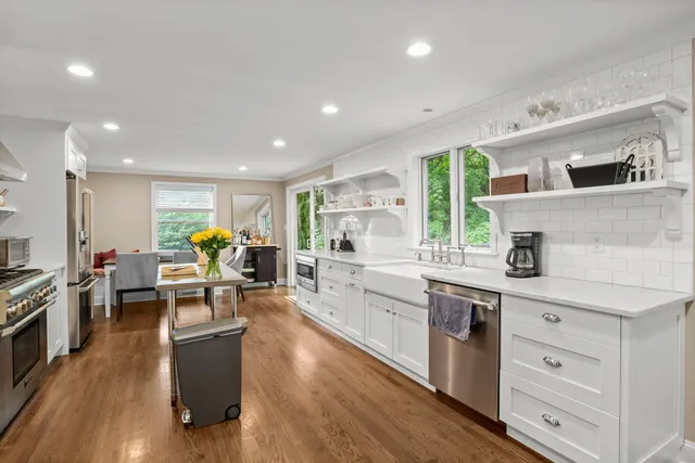 a kitchen with stainless steel appliances granite countertop lots of counter top space and wooden floor
