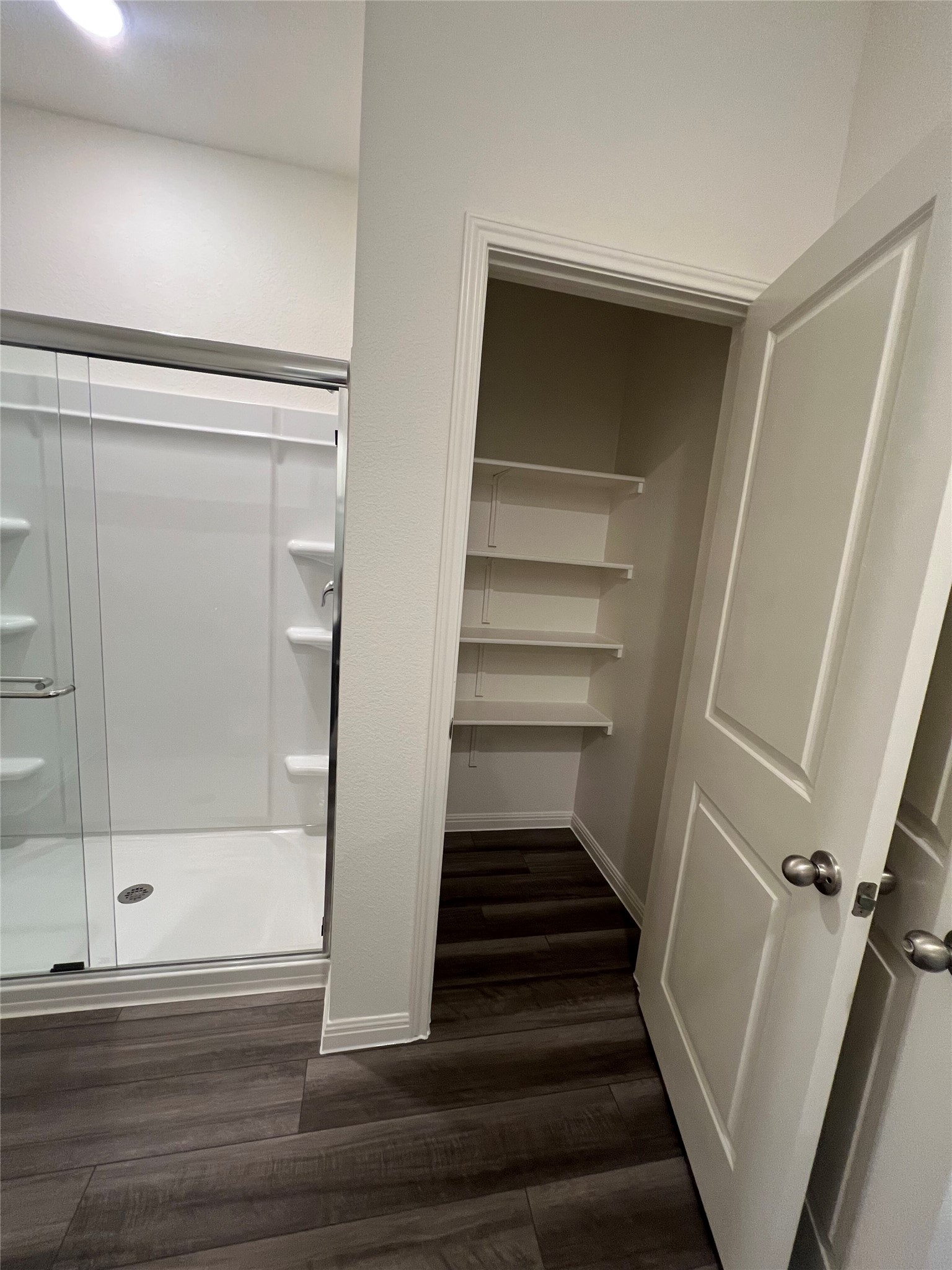 124 Rother Place Taylor, TX 76574 - Photo 6 of 12 Functional bathroom features a glass-enclosed shower alongside convenient built-in shelving.