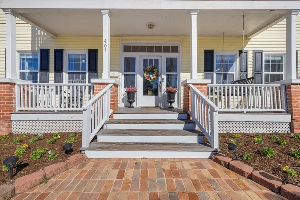 a view of a house with wooden deck and furniture