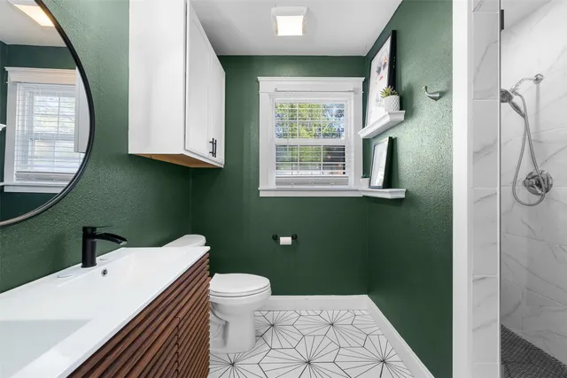 a bathroom with a sink a toilet and a mirror