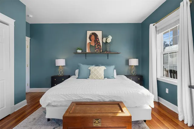 a bedroom with a bed and a painting on the wall