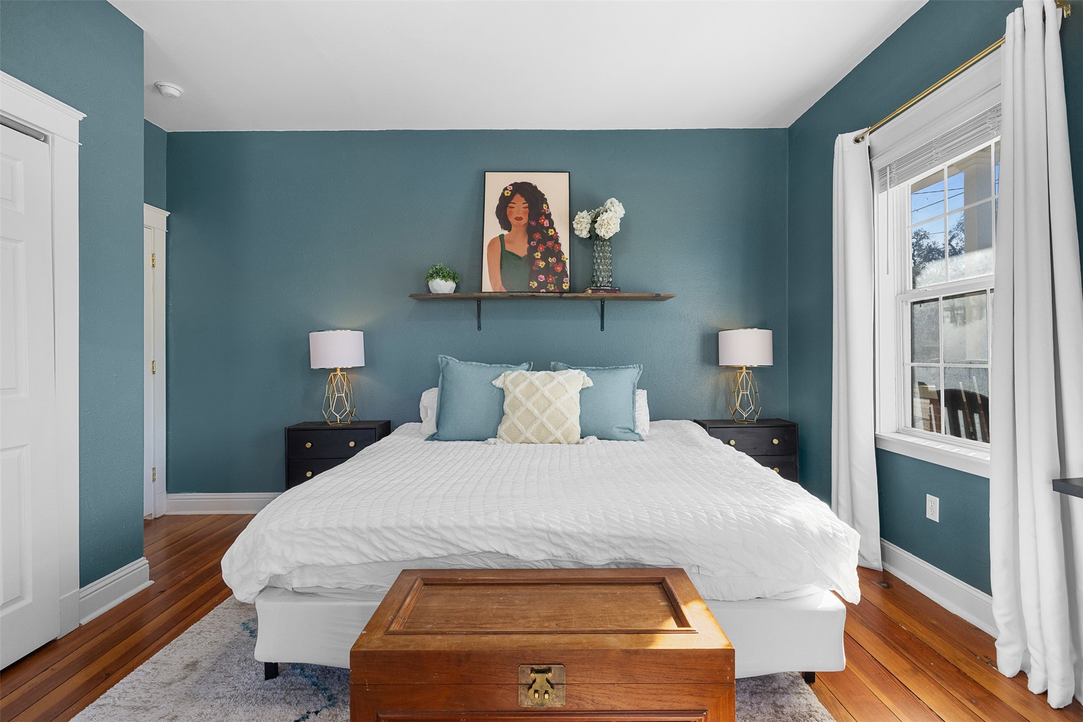 407 East Alamo Street Brenham, TX 77833 - Photo 17 of 27 a bedroom with a bed and a painting on the wall