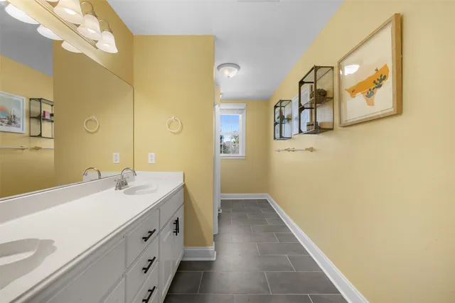 a spacious bathroom with a double vanity sink a mirror and a shower