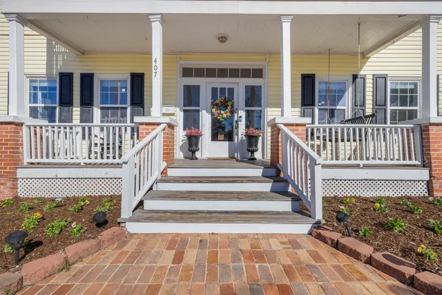 a view of a house with wooden deck and furniture