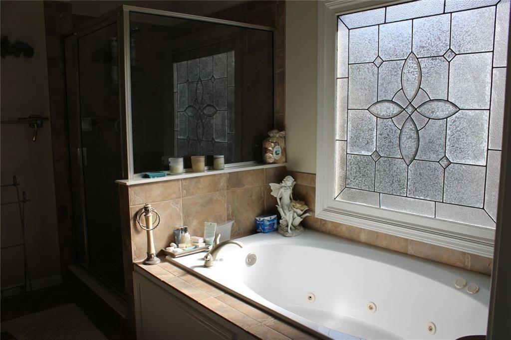 3411 Jim Moore Road Dacula, GA 30019 - Photo 28 of 54 a bathroom with a tub and shower