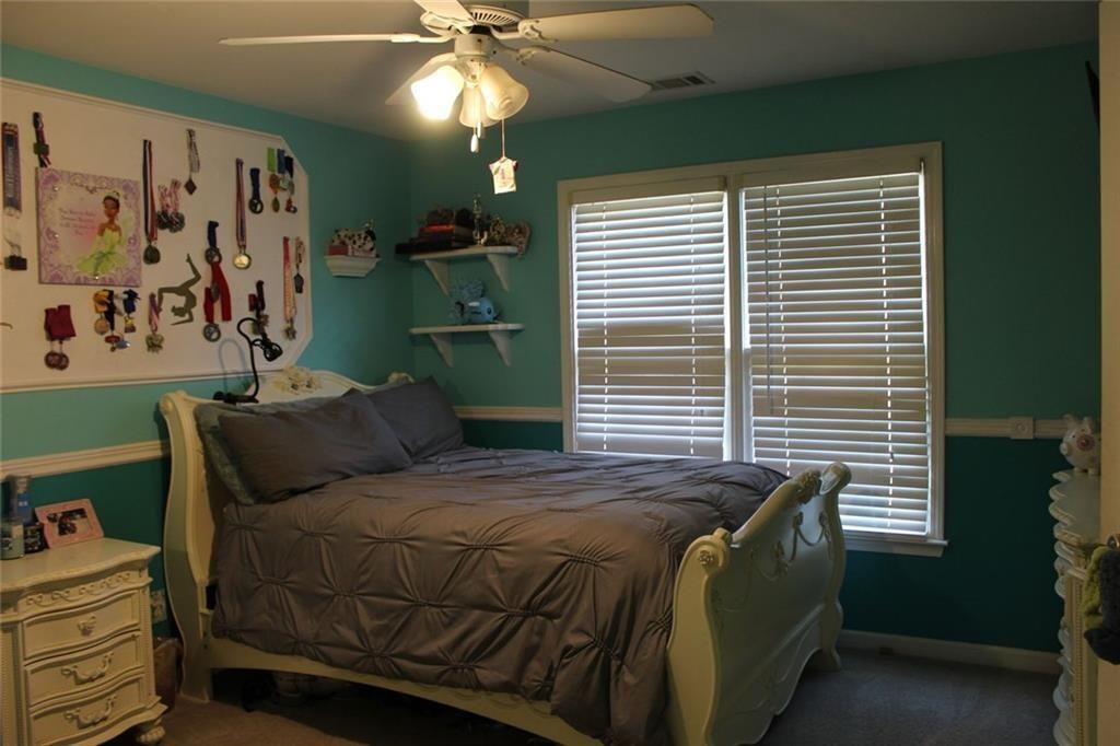 3411 Jim Moore Road Dacula, GA 30019 - Photo 42 of 54 a bedroom with a bed and a chandelier