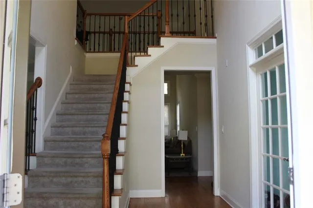 a view of staircase with lots of frames on wall and wooden floor