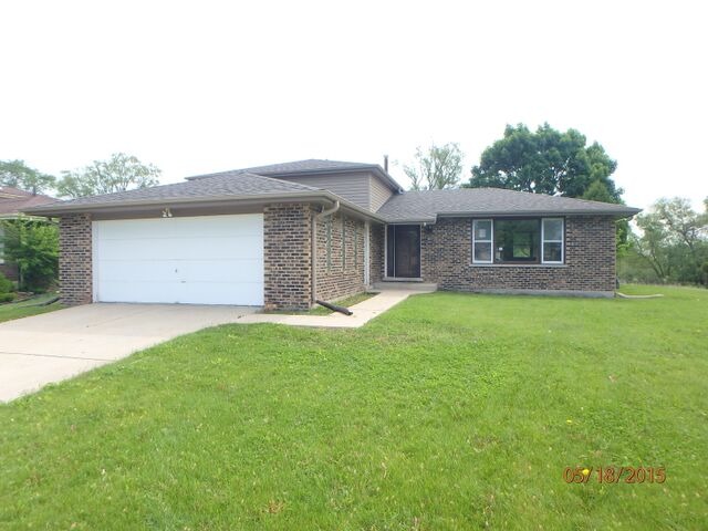 557 Old Meadow Road Matteson, IL 60443 - Photo 1 of 16 a front view of house with yard and porch