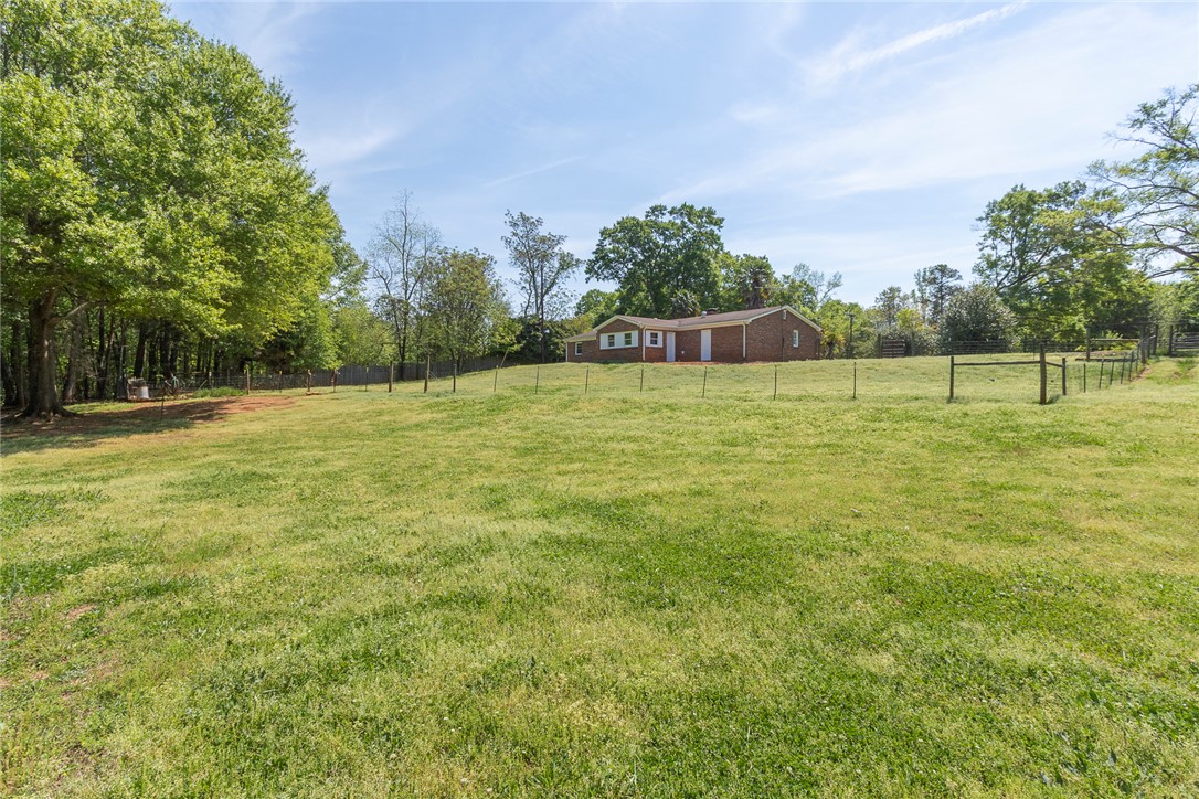 820 Travis Road Anderson, SC 29626 - Photo 39 of 46 Vast green expanse featuring a charming brick residence nestled amidst mature trees.