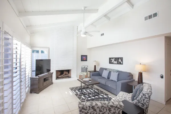 a living room with furniture a flat screen tv and a fireplace