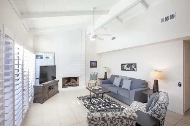 a living room with furniture a flat screen tv and a fireplace