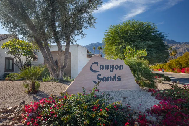 a sign that is sitting in front of flowers