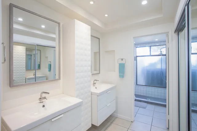 a bathroom with a double vanity sink mirror and bathtub