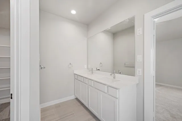 a bathroom with a double vanity sink and mirror