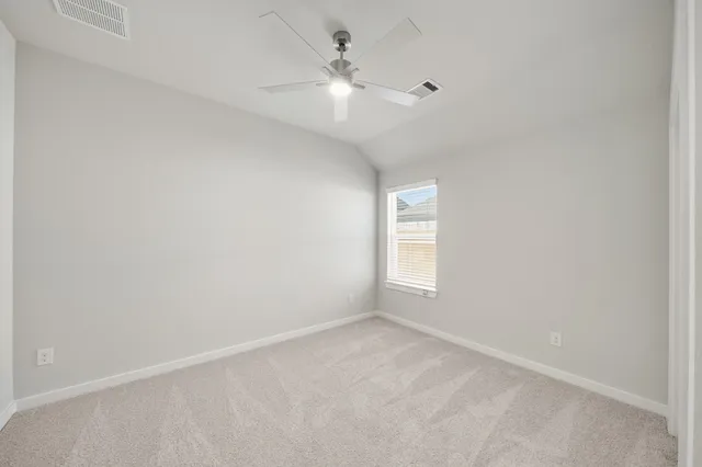 an empty room with a window and a fan