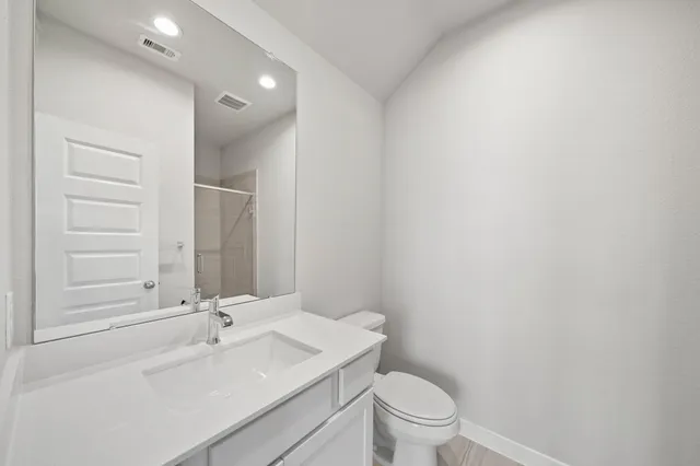 a bathroom with a sink a toilet and a mirror