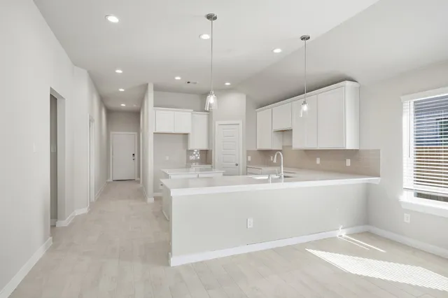 a large kitchen with a sink and a large window