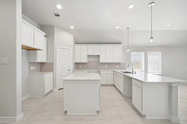 a large kitchen with cabinets and stainless steel appliances