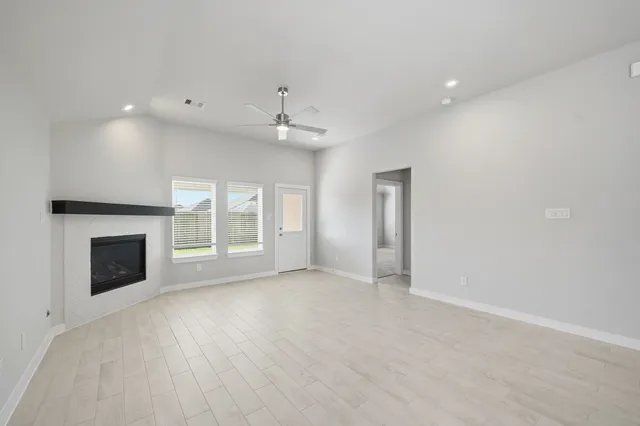a view of an empty room with a fireplace and a window