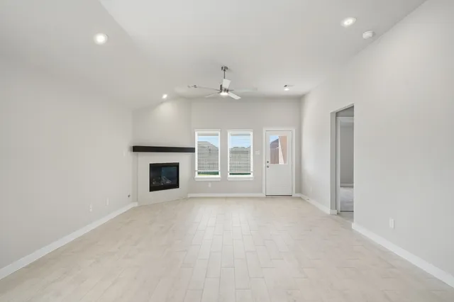 an empty room with windows and fireplace