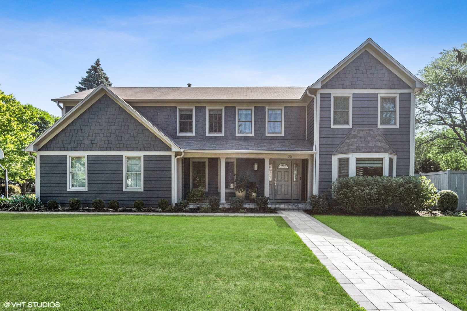a front view of a house with a garden and yard