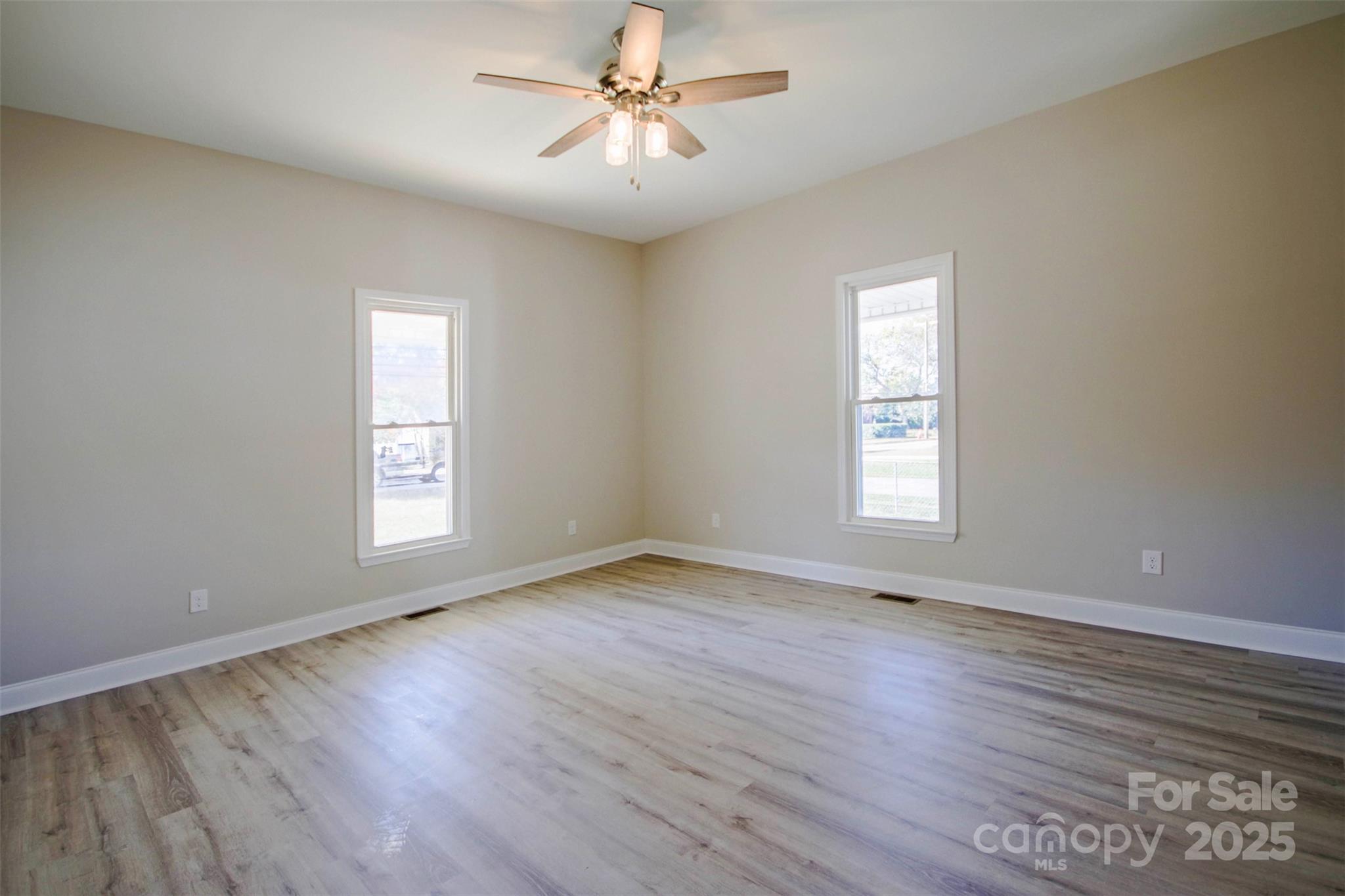 119 Marion Street Clover, SC 29710 - Photo 17 of 45 an empty room with wooden floor ceiling fan and windows