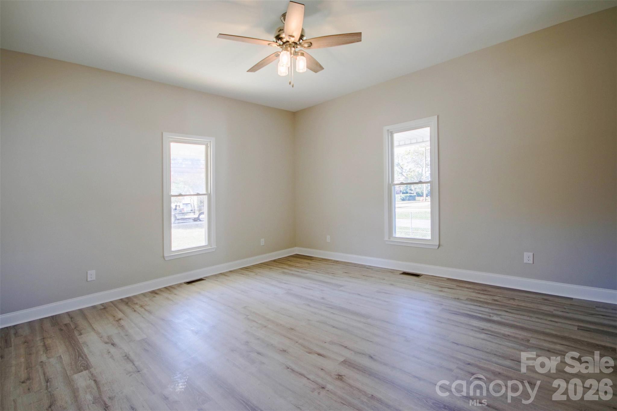 119 Marion Street Clover, SC 29710 - Photo 18 of 46 an empty room with wooden floor ceiling fan and windows