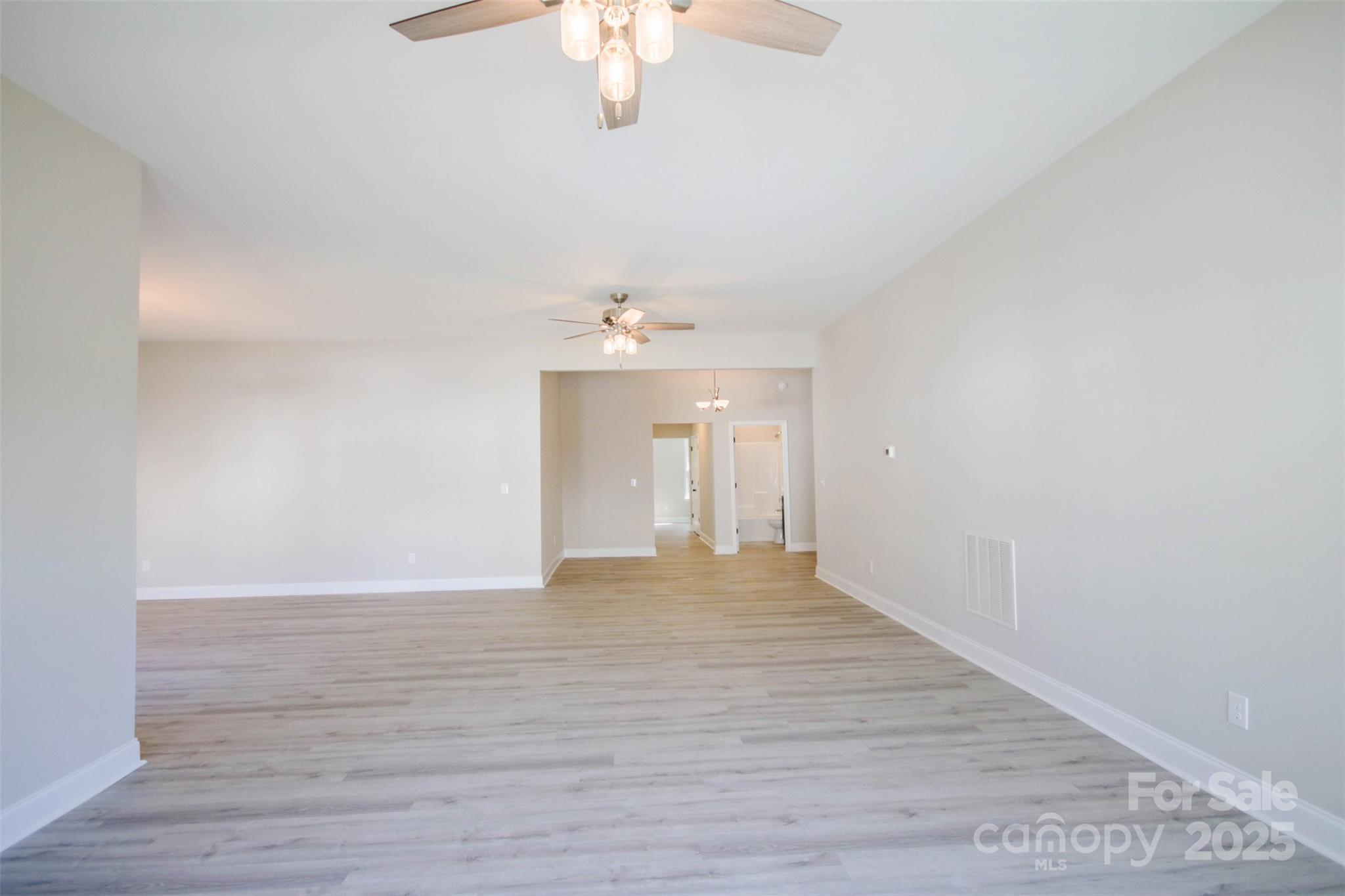 119 Marion Street Clover, SC 29710 - Photo 27 of 45 a view of an empty room with wooden floor and a chandelier