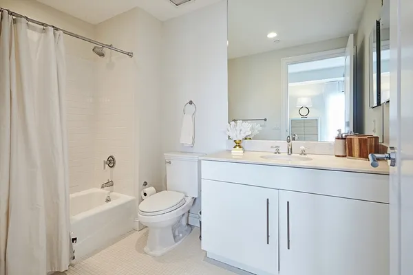 a bathroom with a sink a toilet and a large mirror