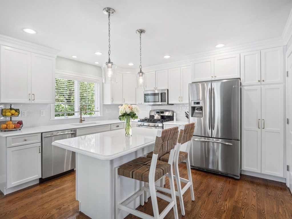 2 Mellen Street, Unit 2 Needham, MA 02494 - Photo 5 of 26 a kitchen with stainless steel appliances granite countertop a refrigerator a sink dishwasher a stove and white cabinets with wooden floor