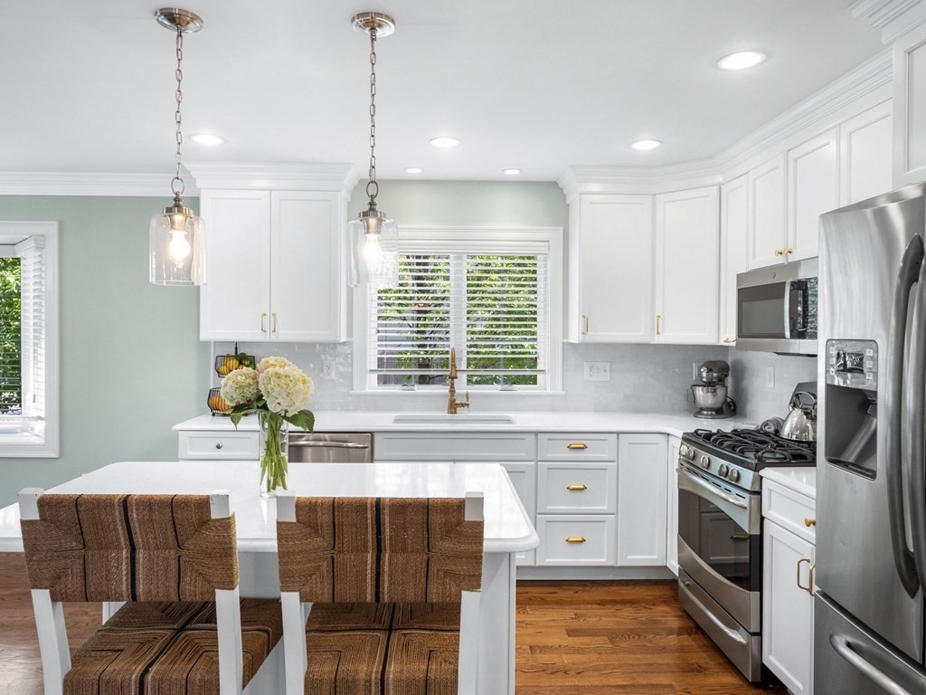 2 Mellen Street, Unit 2 Needham, MA 02494 - Photo 6 of 26 a kitchen with stainless steel appliances granite countertop a stove top oven a refrigerator a sink and dishwasher with wooden floor