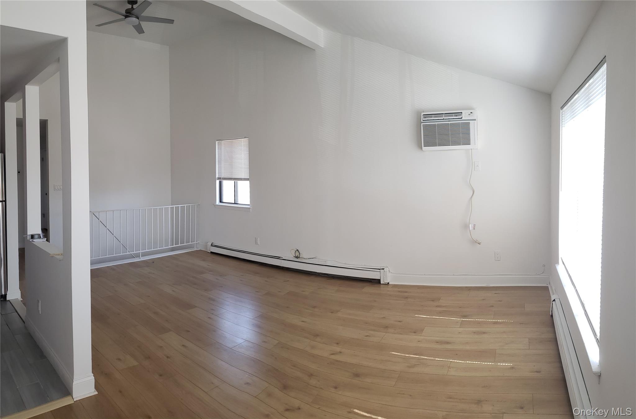 184-11 144th Road Queens, NY 11413 - Photo 14 of 16 an empty room with wooden floor and windows